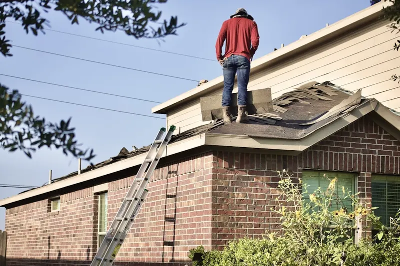 Professional roofer working on a residential roof in Starkville